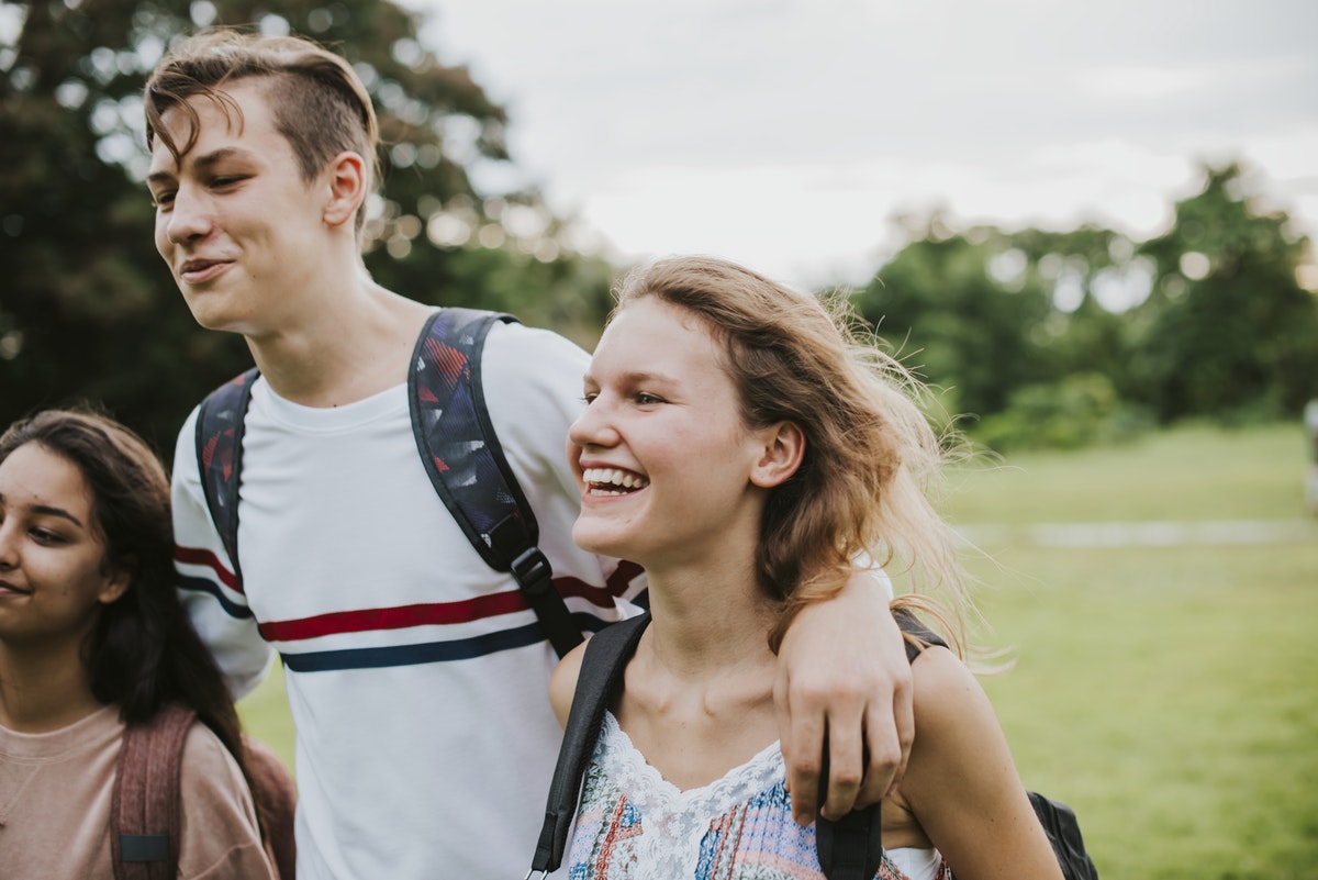three students walk with backpacks on, male in the middle with hands around the shoulders. best online therapy and counseling services. find the best therapy online